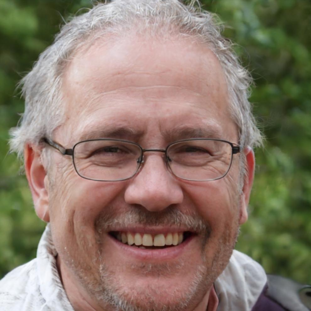 Porträtfoto von Rainer Mühlbauer, lächelnder Finanzberater mit grauem Haar
